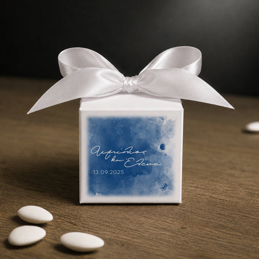 White paper cube favor box 7.5 × 7.5 × 7.5 cm, made from thick 400 gsm paper with printed sticker and ribbon in your choice of color – elegant wedding favor box. Theme: Blue Romance.
